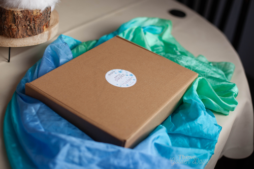 Brown box with a label on a blue and green silk.