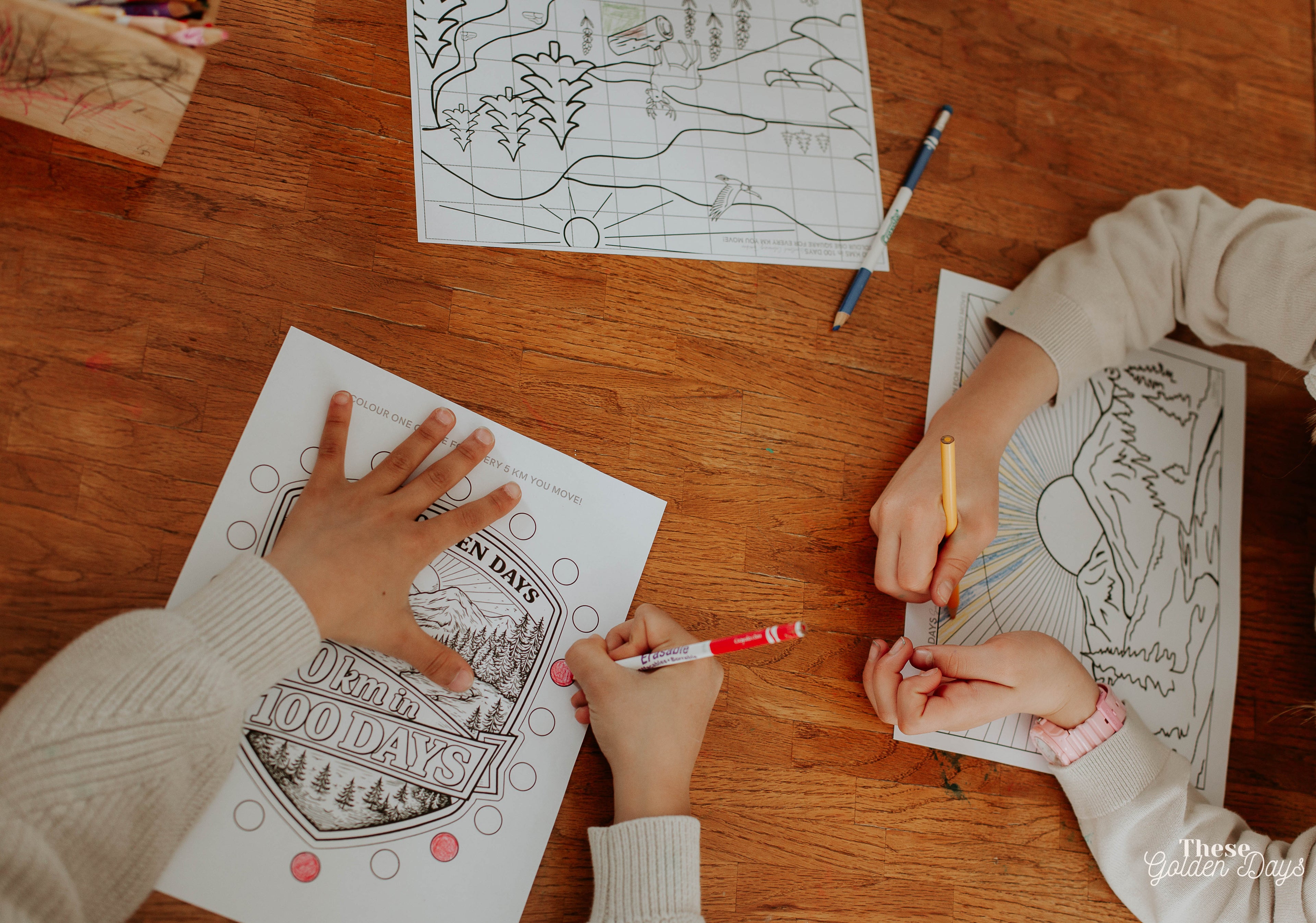 Two children coloring at a table with coloring books and markers.