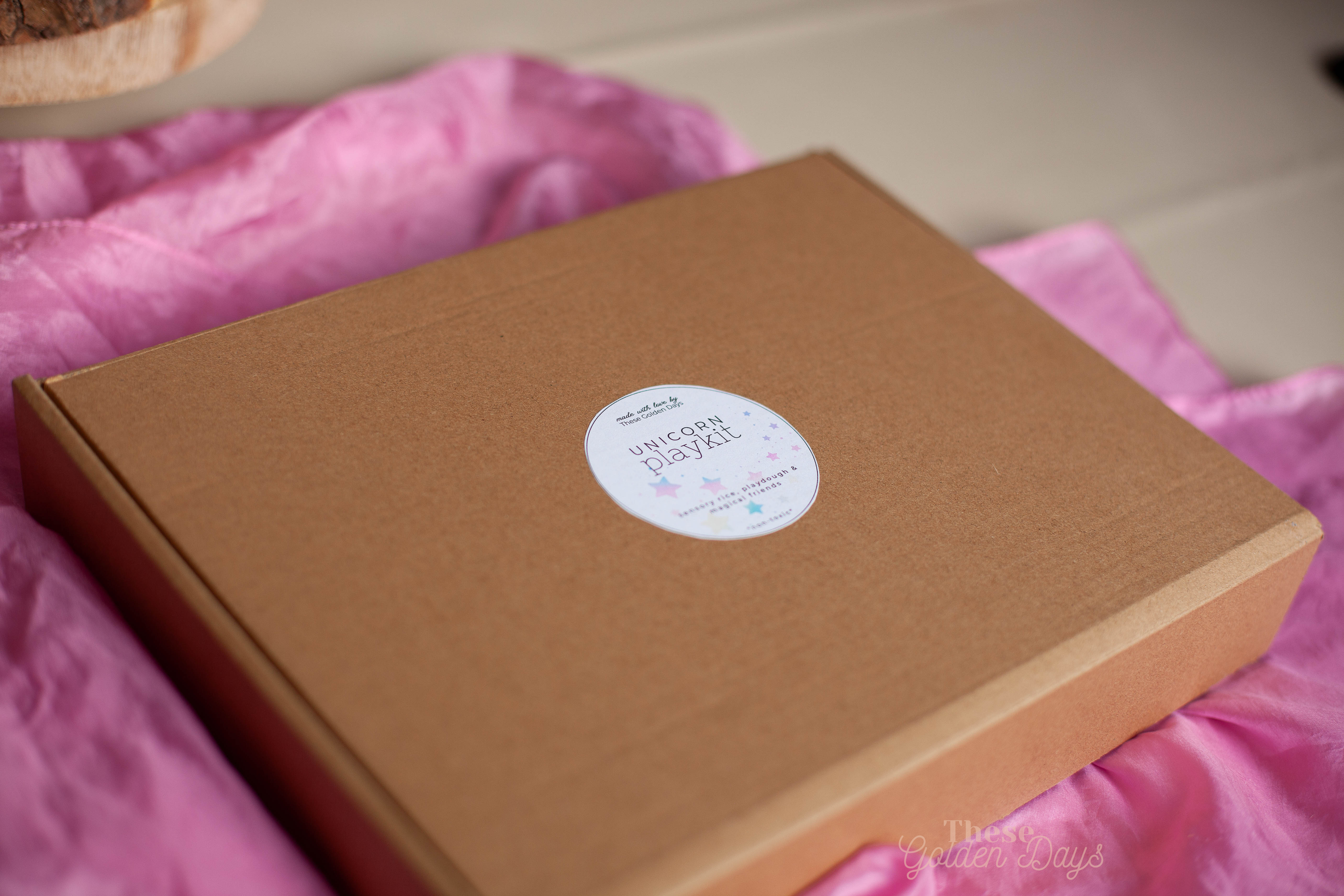 Brown box with a white label on a pink silk fabric background