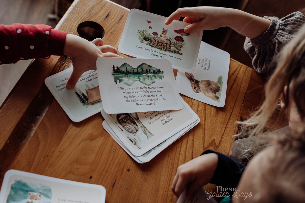 Children playing with illustrated cards on a wooden table